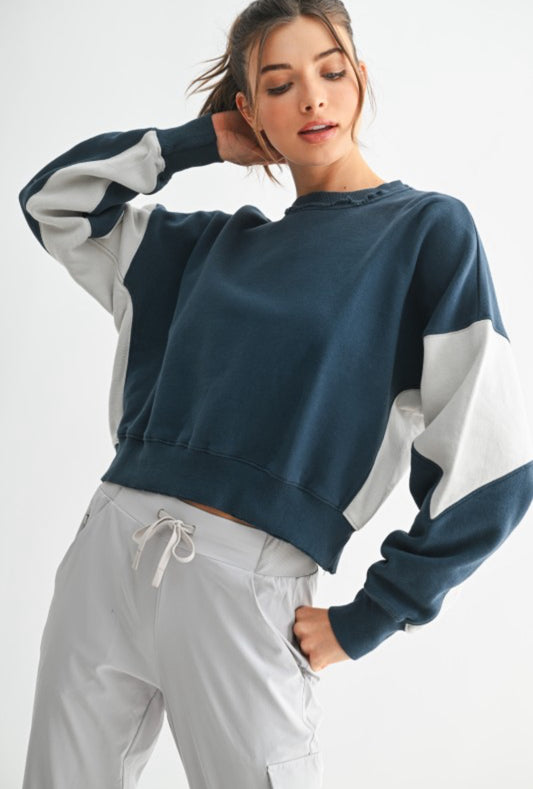 Model wearing midnight and pale gray color block oversized sweatshirt with joggers.