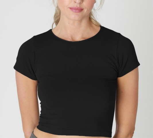 Front view of NIKIBIKI Jersey Solid Baby Tee in black – cropped fitted crew neck t-shirt with short sleeves, styled with tailored pants.